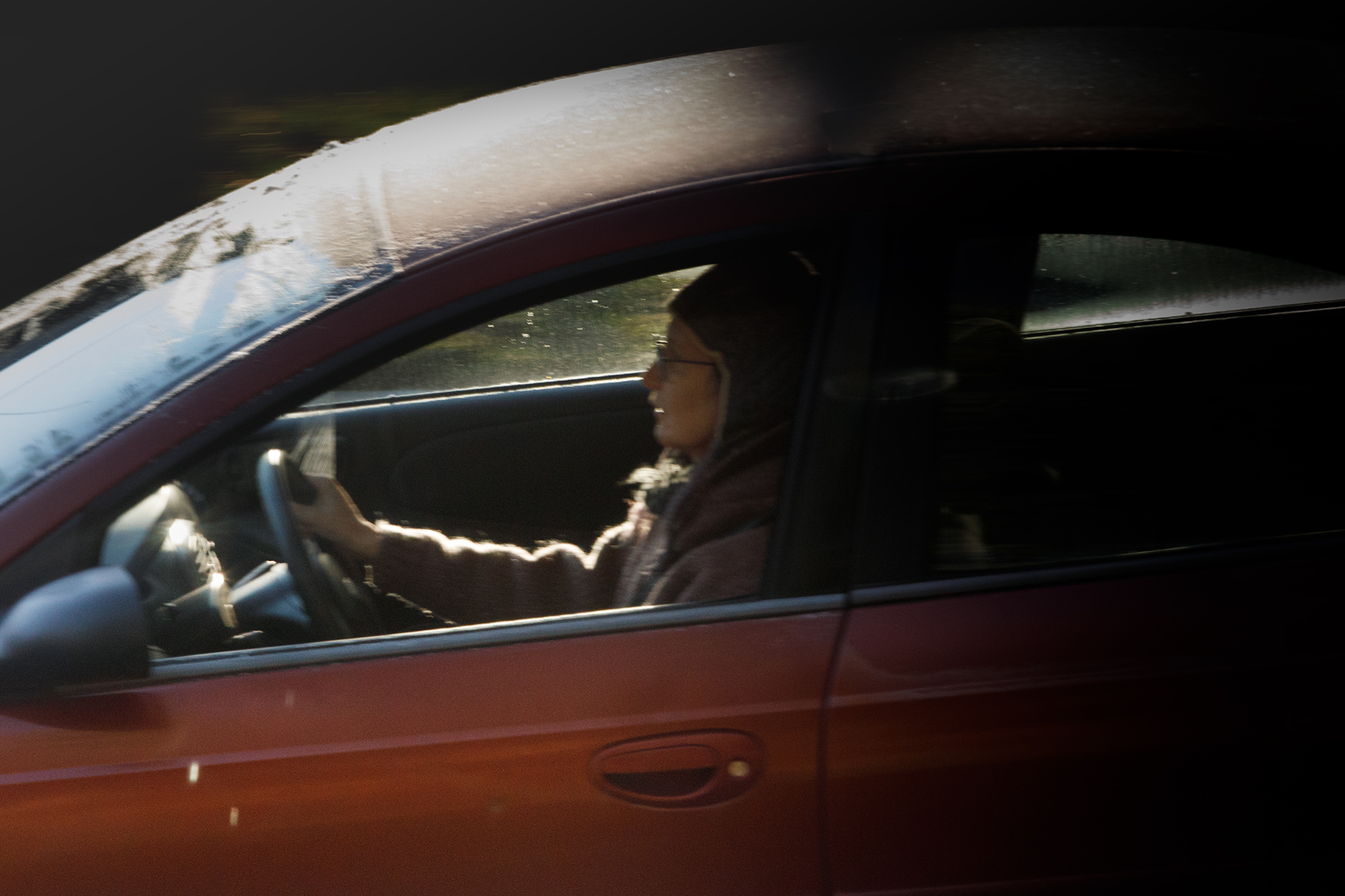 closeup of artist driving car, backlit