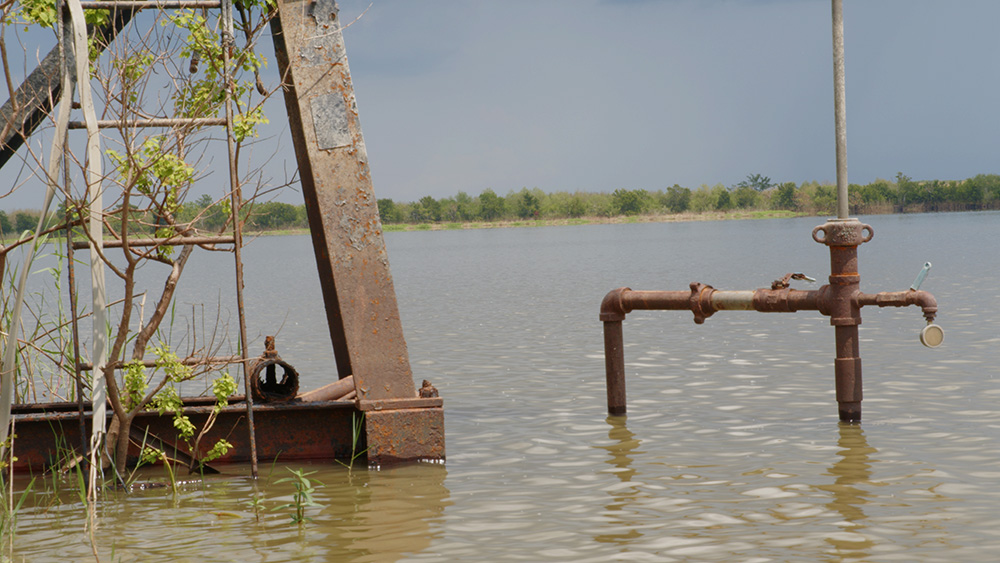 Landscape with lake and oil pipejack remnants